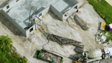 Yeni Florida evinin şantiyesi. Ahşap çatı kirişleri döşenmeye hazır tuğla beton duvarlı, tamamlanmamış özel evin havadan görüntüsü. Endüstriyel yapı.