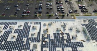 Ticari alışveriş merkezinin çatısına yeşil ekolojik elektrik üretmek için monte edilmiş mavi fotovoltaik panelleri olan güneş enerjisi santrali. Sürdürülebilir enerji konsepti üretimi.