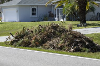Florida yerleşim bölgesindeki kasırga sonrası kurtarma kamyonu için yol kenarındaki çöp yığınları. Doğal afetin sonuçları..