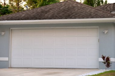 Wide garage double door and concrete driveway of new modern american house.