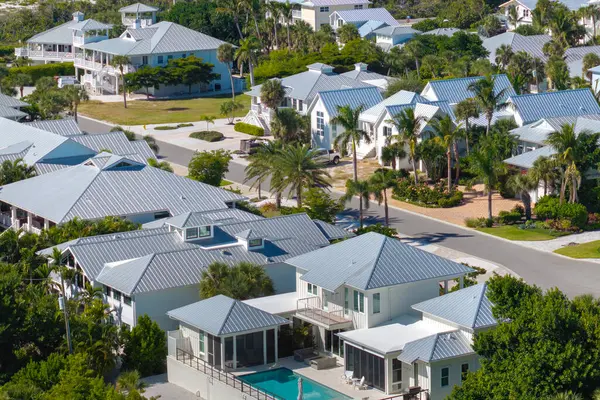 Expensive mansions between green palm trees in southwest Florida suburbs, USA. Aerial view of wealthy waterfront neighborhood.