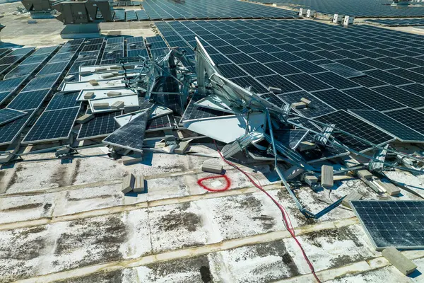 stock image Top view of destroyed by hurricane Ian photovoltaic solar panels mounted on industrial building roof for producing green ecological electricity. Consequences of natural disaster in Florida.