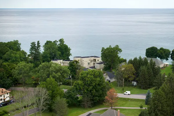 Two-story residential waterfront houses on lake Ontario shore in rural living area in Rochester, NY. American dream homes as example of real estate development in US suburbs.