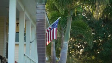 Florida 'daki banliyö evinde ABD bayrağı ön bahçede dalgalanırken. Amerikan yıldızları ve çizgileri demokrasinin sembolü olarak gösterildi..