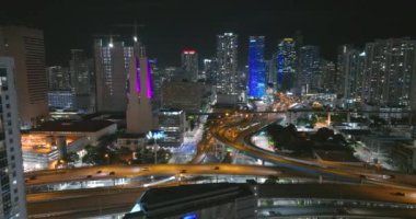 Miami şehri gece manzarası büyük otoyol kavşağı ve şehir merkezindeki yüksek binalar. ABD 'de kentsel altyapı kavramı.