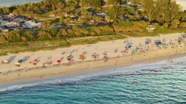 Nokomis, Florida. ABD 'nin Sarasota eyaletindeki Sandy plajı. Birçok insan sıcak körfez suyunda banyo yapmaktan ve gün batımında sıcak güneşin altında bronzlaşmaktan keyif alır..