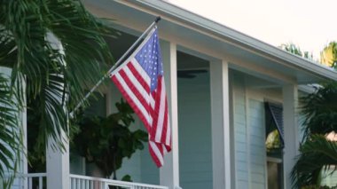 Florida özel evinin ön bahçesinde Amerikan bayrağı dalgalanıyor. Demokrasinin sembolü olarak gösterilen Amerikan yıldızlarının ve çizgilerinin havadan görünüşü.