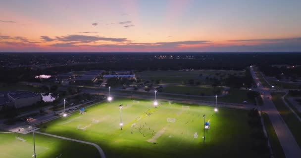 サッカーの試合を日没でプレーする若者がいる公共スポーツスタジアム アクティブなライフ コンセプト — ストック動画