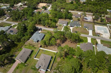 Aerial landscape view of suburban private houses between green palm trees in Florida quiet rural area.