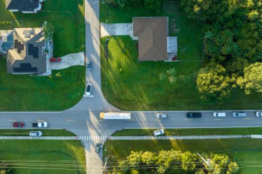 Sabahın erken saatlerinde Amerikan sarı okul otobüsünün kaldırımdaki otobüs durağından çocukları aldığı hava görüntüsü. ABD 'de toplu taşıma.