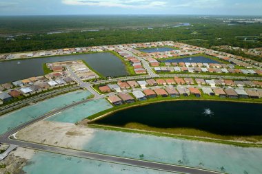 Aerial view of construction site with new tightly packed homes in Florida closed living clubs. Family houses as example of real estate development in american suburbs. clipart