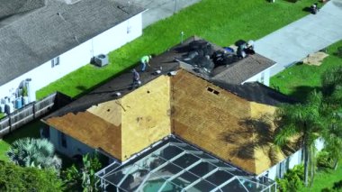 İnşaat işçileri çatı kaplamasını değiştiriyor. Florida 'daki evin tamiri. Çatıdan eski asfalt kiremitlerin çıkarılması. Gayrimenkul geliştirme kavramı.
