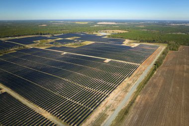 Temiz elektrik enerjisi üretmek için sıra sıra güneş fotovoltaik panelleri olan sürdürülebilir büyük elektrik santralinin havadan görünüşü. Sıfır emisyonlu yenilenebilir elektrik kavramı.