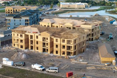 İnşaat halindeki apartmanların bitmemiş ahşap çerçevelerinin havadan görüntüsü. Amerikan banliyölerinde konut geliştirme. ABD 'de emlak piyasası.