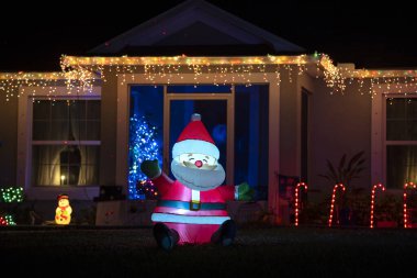 Ön bahçede parlak ışıklandırılmış noel süslemeleri var. Florida aile evinin dışında kış tatili için..