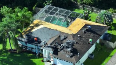 İnşaat işçileri çatı kaplamasını değiştiriyor. Florida 'daki evin tamiri. Çatıdan eski asfalt kiremitlerin çıkarılması. Gayrimenkul geliştirme kavramı.