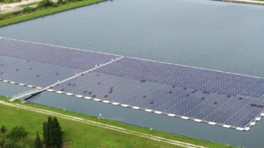 Temiz elektrik enerjisi üretmek için birçok sıra güneş paneli bulunan yüzen fotovoltaik enerji santrali. Su yüzeyinde hava kirliliği olmayan yenilenebilir elektrik kavramı.