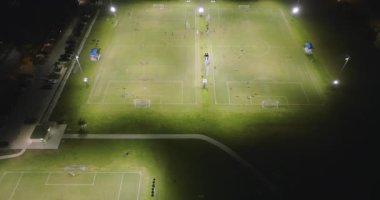 North Port, Florida 'da halk spor sahasında geceleri çimen futbol stadyumunda futbol oynayan insanlarla aydınlandı. Açık hava aktiviteleri konsepti.