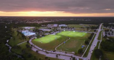 Kuzey Port, Florida 'da halk spor sahasında gün batımında çimen futbol stadyumunda futbol oynayan insanlarla aydınlandı. Açık hava aktiviteleri konsepti.