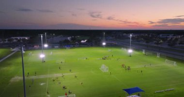 İnsanlar gün batımında halka açık stadyumda futbol oynuyorlar. Aktif yaşam konsepti.