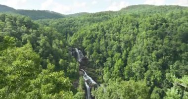 Whitewater Şelalesi 'nin kayalık kayalardan dökülen temiz sularıyla Nantahala Ulusal Ormanı, Kuzey Carolina, ABD' deki yeşil yemyeşil ağaçlar arasında..