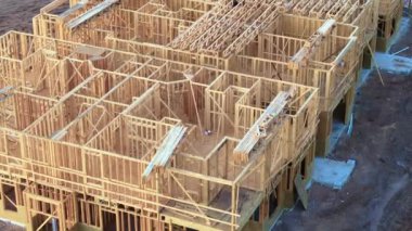 Apartmanın ahşap iskelesi inşaat halindeki çatı kirişleri için hazır. Amerikan banliyölerinde konut geliştirme. ABD 'de emlak piyasası