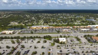North Port, Florida 'da alışveriş merkezleri ve araba sürücüleri olan çok şeritli Amerikan yolu. ABD 'nin perakende ve ulaştırma altyapısının üzerinden görüntüle