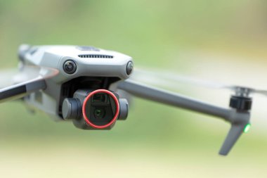 Drone quadcopter with digital camera and fast rotating propellers flying taking video and pictures.
