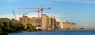 Tower cranes and frame structure of high residential apartment buildings at construction site. Real estate development.