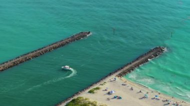 Nokomis plaj okyanusu körfezi yelkenli tekneler ve Sarasota 'da Kuzey ve Güney Jetty, ABD. Birçok insan sıcak körfez suyunda banyo yapmaktan ve sıcak Florida güneşinin altında bronzlaşmaktan keyif alıyor..