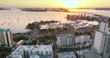 Sarasota, Florida, gün batımında. Sarasota Körfezi marinasına yanaşmış lüks yatlar. Yüksek katlı ofis binaları olan Amerikan şehir mimarisi. ABD seyahat hedefi