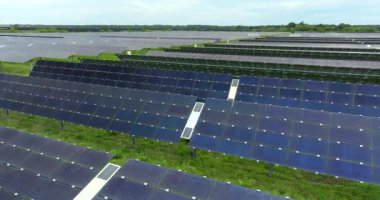 Temiz elektrik enerjisi üretmek için birçok sıra güneş paneli bulunan fotovoltaik enerji santralinin üzerinden görüntülenebilir. Hava kirliliği olmayan yenilenebilir elektrik kavramı.