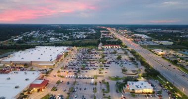 Gün batımında alışveriş merkezleri. Kuzey Port, Florida 'da ışıklı Amerikan yolu ve sürüş arabaları. ABD perakende ve ulaşım altyapısı.