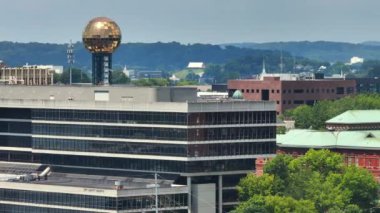 ABD 'nin Tennessee eyaletinin Knoxville şehir merkezindeki şehir manzarası. Dünya Fuar Parkı 'ndaki güneş küresi ve yüksek ticari binalarla Amerikan şehrinin ufuk çizgisi.