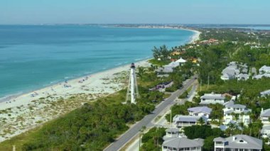 Boca Grande, Florida mimarisi. Beyaz deniz feneri kulesi ve yeşil palmiye ağaçları arasında pahalı rıhtım evleri olan zengin bir mahalle. ABD Premium Konutlarının Geliştirilmesi.