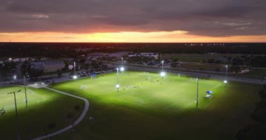 Gün batımında futbol oynayan gençlerle dolu bir stadyum. Aktif yaşam konsepti.
