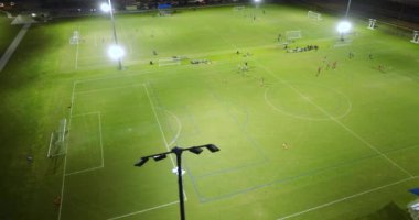 Okul çocukları, Florida, North Port 'taki futbol stadyumunda futbol antrenmanı yapıyor..