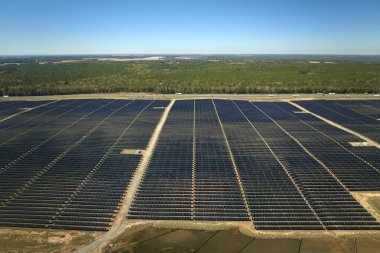 Temiz elektrik enerjisi üretmek için birçok sıra güneş fotovoltaik paneli bulunan sürdürülebilir büyük elektrik santralinin havadan görünüşü. Sıfır emisyon kavramı ile yenilenebilir elektrik.