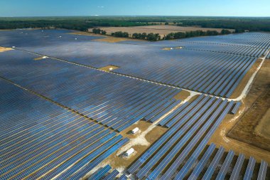 Temiz elektrik enerjisi üretmek için sıra sıra güneş fotovoltaik panelleri olan sürdürülebilir büyük elektrik santralinin havadan görünüşü. Sıfır emisyonlu yenilenebilir elektrik kavramı.