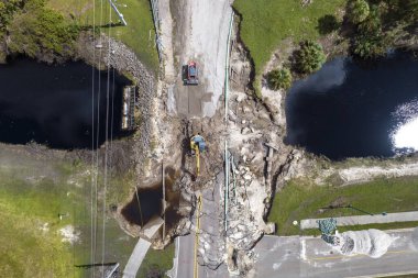 Yol çalışması alanında inşaat malzemeleri. Sel suları asfaltı yıkadıktan sonra yıkılan hasarlı yol köprüsünün yeniden inşası. Yıkılmış ulaşım altyapısının yeniden inşası.
