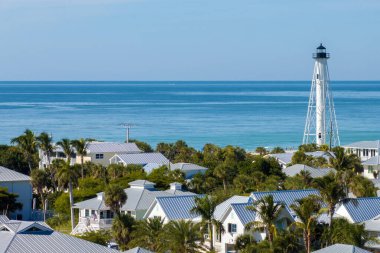 Large residential homes and tall lighthouse in island small town Boca Grande on Gasparilla Island in southwest Florida. American waterfront houses in rural US suburbs. clipart