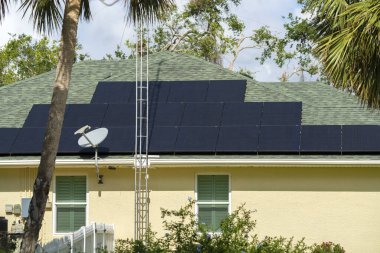 Banliyö bölgesinde temiz ekolojik elektrik üretimi için güneş panelleriyle kaplı Amerika 'daki sıradan bir ev. Enerji tasarrufu için özerk eve yatırım yapma kavramı.