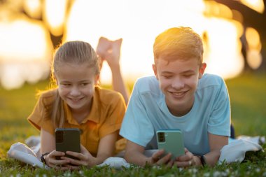 Arkadaşlarıyla cep telefonuyla mesajlaşan mutlu çocukların portresi