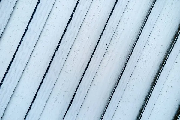 Stock image Aerial view of snow covered sustainable electric power plant with rows of solar photovoltaic panels for producing clean electrical energy. Low effectivity of renewable electricity in northern winter.