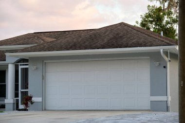 Geniş garaj, çift kapı ve modern Amerikan evinin beton yolu..