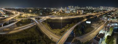 Gece Miami, Florida 'daki geniş otoyol kavşağının üstünde hızlı sürüş yapan arabalarla. ABD ulaştırma altyapı kavramı.