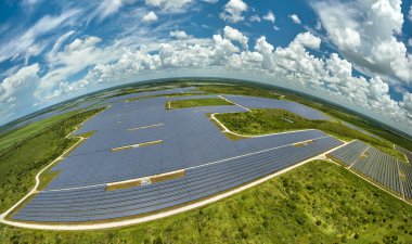 Temiz elektrik enerjisi üretmek için sıra sıra güneş fotovoltaik panelleri olan sürdürülebilir büyük elektrik santralinin havadan görünüşü. Sıfır emisyonlu yenilenebilir elektrik kavramı.