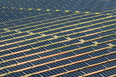 Temiz elektrik enerjisi üretmek için sıra sıra güneş fotovoltaik panelleri olan sürdürülebilir büyük elektrik santralinin havadan görünüşü. Sıfır emisyonlu yenilenebilir elektrik kavramı.