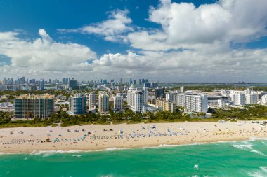 Güney Amerika 'da seyahat ve turizm altyapısı. Güney Sahili 'nin kumlu yüzeyi. Sıcak Florida güneşinde dinlenen turistler. Yüksek lüks otelleri ve apartmanları olan Miami Beach City..