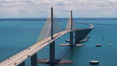 Florida 'daki Tampa Körfezi üzerinde Sunshine Skyway Köprüsü' nde araba sürüyor. Amerika 'da ulaşım altyapısı.